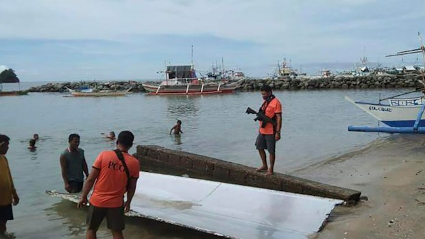 In this handout photo provided by the Philippine Coast Guard, Coast Guard personnel inspect debris, which the Philippine Space Agency said has markings of the Long March 5B (CZ-5B) Chinese rocket that was launched on July 24,