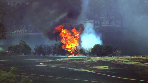 Strong south-westerly winds are fanning flames north of Melbourne, sparking evacuation warnings for more than two dozen towns.