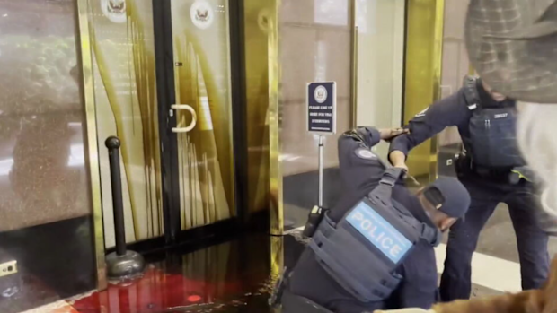 A police officer appeared to slip on the oil spill outside the American Consulate in Melbourne.