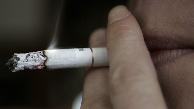 A woman smokes a cigarette.