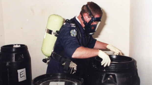 A police officer examines barrels in the Snowtown killings.