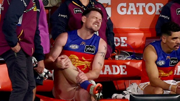 Lachie Neale of the Lions limps to the bench injured.