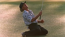 Greg Norman collapses on the ground after narrowly missing his chip shot on the 15th green.