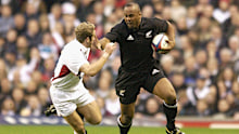 Jonah Lomu of New Zealand goes past James Simpson-Daniel of England.