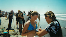 Carmen (R) began training straight out of high school, hoping to make it in the professional surfing world.