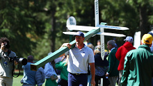 Bryson DeChambeau moves a sign while preparing to play his second shot on the 13th hole.