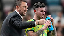 Australia's head coach Tony Popovic, center, talks with Australia's Aiden O'Neill (13) during a break in the first half of an international friendly soccer match against Venezuala, Friday, Nov. 14, 2025, in Houston. (AP Photo/Karen Warren)
