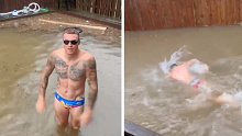 Mitch Robinson poses in his flooded backyard before going for a swim. 