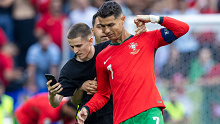 A pitch invader takes a selfie photograph with Portugal forward Cristiano Ronaldo during the UEFA Euro 2024 Group F match between Turkiye v Portugal, at the  BVB Stadion Dortmund in Dortmund, Germany, on June 22, 2024. (Photo by Andrzej Iwanczuk/NurPhoto via Getty Images)