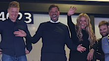 Jurgen Klopp smiles in the stands at Wembley Stadium.