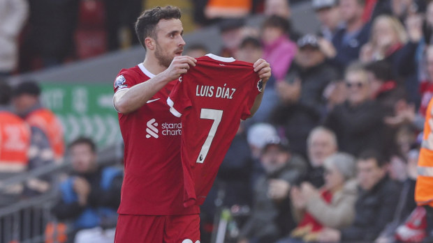 Liverpool's Diogo Jota holds up the shirt of teammate Luis Diaz in tribute.