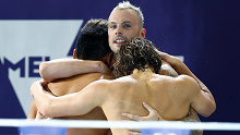 Kyle Chalmers embraces his teammates after their world record relay swim. 