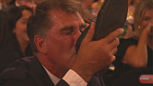 Brisbane coach Craig Starcevich downs a shoey after his player Emily Bates won the AFLW best and fairest award.