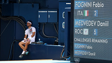 Fabio Fognini sits in the shade while Daniil Medvedev gets treatment.