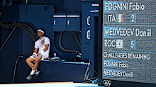 Fabio Fognini sits in the shade while Daniil Medvedev gets treatment.