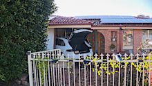 Police are looking for two people after a Porsche ploughed into a house in Sydney's south-west.