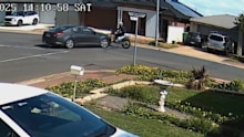 Security cameras have captured the shocking moment a motorbike rider collided with a car and was sent flying through the air - but somehow survived - in Adelaide's northern suburbs.