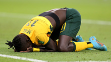 Awer Mabil collapses to the turf in celebration after Australia qualify for the World Cup. 