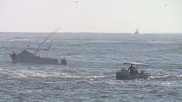 Queensland news: Father and son rescued after boat capsizes during ...