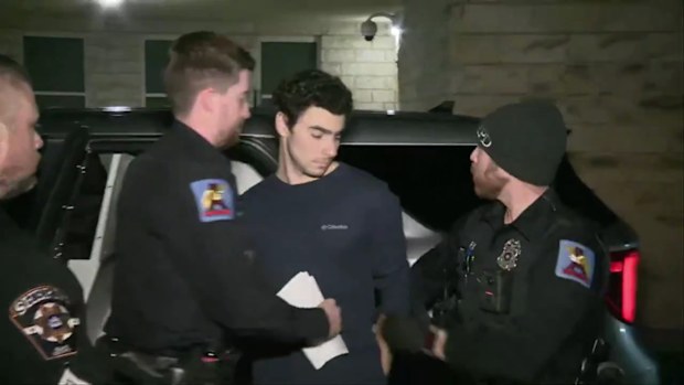 Luigi Mangione being taken by officers into a Pennsylvania courthouse.