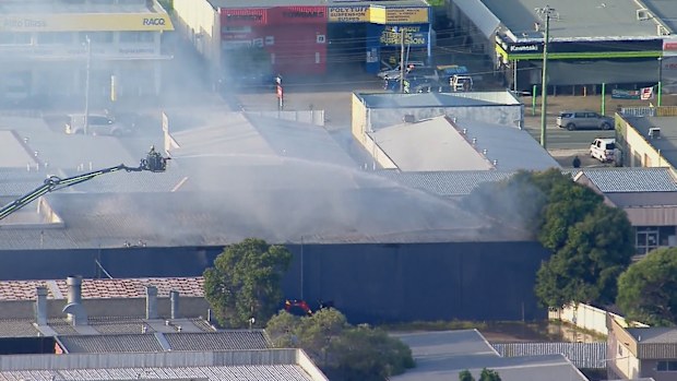 Two female firefighters are in hospital, with one critical, after a blaze engulfed a warehouse south of Brisbane.