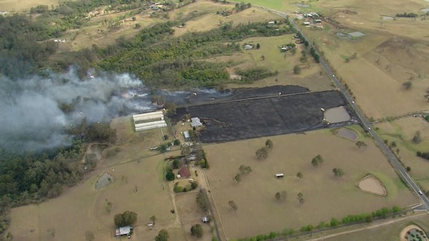 Firefighters are working to extinguish a bushfire that is believed to be threatening homes in Sydney's south west at The Oaks