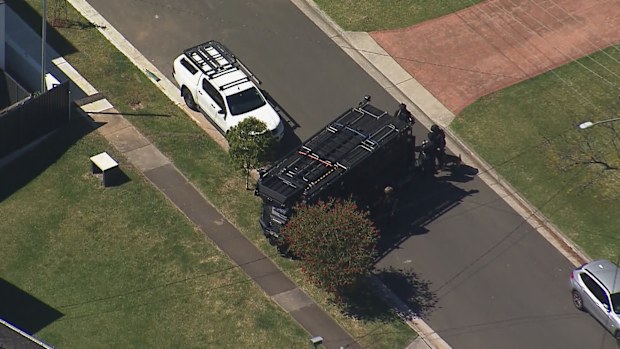 An armoured vehicle is stationed out the front of a home in Sydney's south-west.