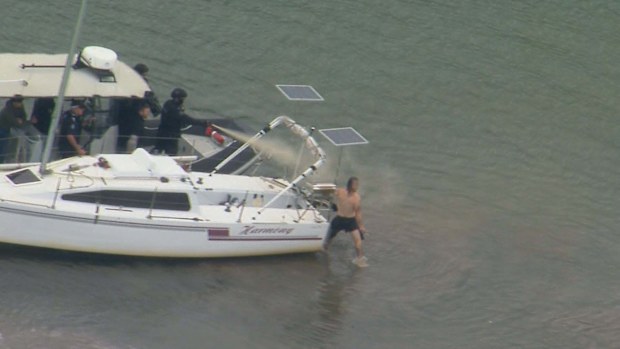 A man has been arrested after crashing an allegedly stolen ute into a house and trying to swim away from police on Queensland's Sunshine Coast.