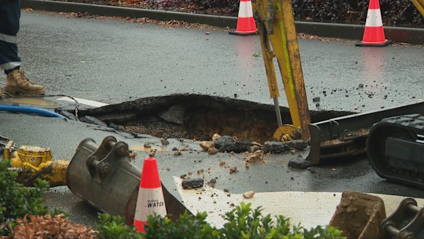 A large sinkhole has opened up on a busy street in Sydney CBD, forcing a nearby school to close and leaving businesses without water.
