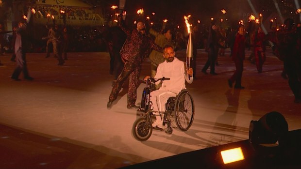 Paralympic flame enters the ceremony.