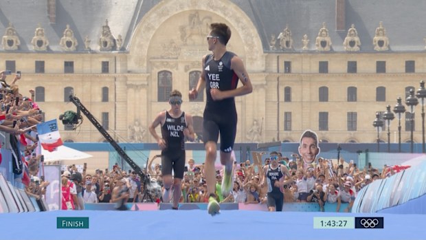 Great Britain's Alex Yee looks over his shoulder after passing New Zealand's Hayden Wilde for the lead of the men's individual triathlon.