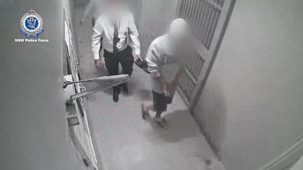 The accused with police before he was charged with murder.