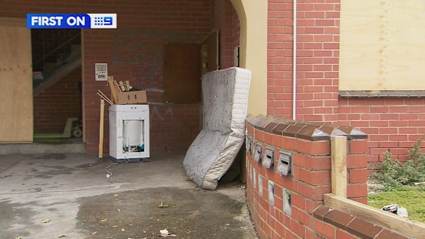 A man has been saved by his neighbours after they saw him hanging from the window of his burning apartment in Melbourne.