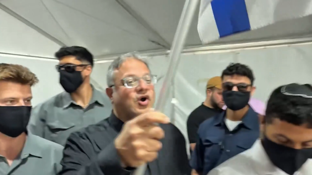 Itamar Ben-Gvir waved an Israeli flag while walking among protesters in handcuffs kneeling on the floor.