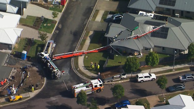 A home in the Queensland city of Ipswich has been left badly damaged after a crane carrying concrete pumping equipment toppled into the property.