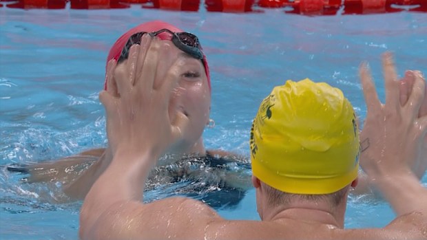 Team Australia celebrates with Team GB in the mixed 4x100m freestyle S14 relay.