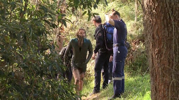 A woman who was mauled by two out of control dogs while sinking into mud on the banks of a Sydney river has told Sutherland local court she thought she was going to die.The alleged owner of the Irish wolfhounds has been charged over the attack and is accused of running away.
Footage shows Elle Booth up to her shoulders in mud clinging to her Jack Russell, under attack.