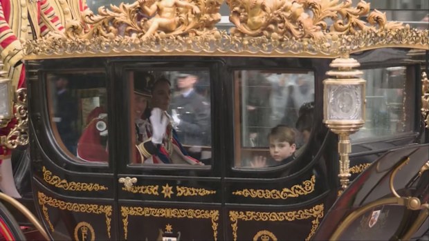 The Wales family wave from the back of a royal carriage after the coronation of King Charles.