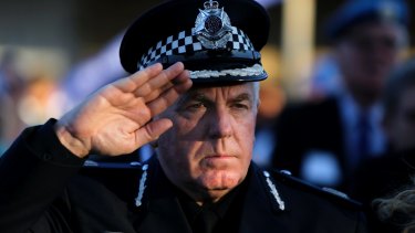 Australian police assistant commissioner Chris Oneill salutes during a flag-lowering ceremony to ended Australia's peacekeeping contribution.