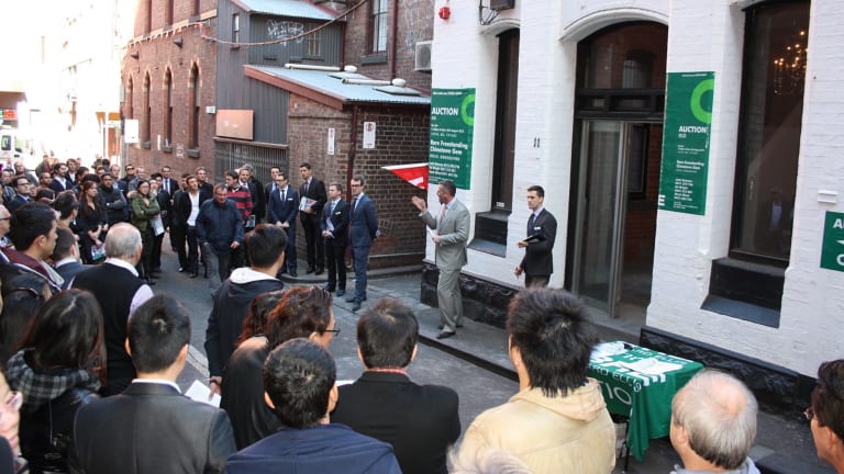 A huge crowd gathers for a Melbourne CBD auction of retail and office premises.