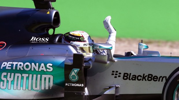 Hamilton waves to the crowd after crossing the finish line.