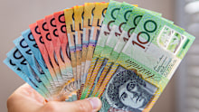 hand holding assortment of Australian cash notes
