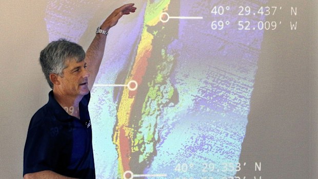 OceanGate CEO and co-founder Stockton Rush speaks in front of a projected image of the wreckage of the ocean liner SS Andrea Doria during a presentation on their findings after an undersea exploration, on June 13, 2016, in Boston.