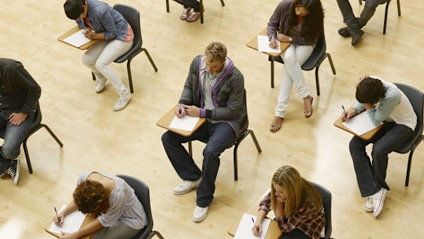 University students are pictured taking an exam in a lecture hall.