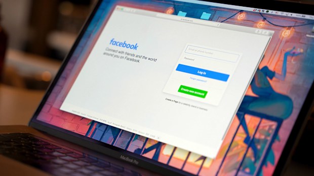 A Facebook login page appears on a computer
