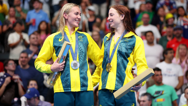 Gold Medalist Mollie O'Callaghan (R) and Silver Medalist Ariarne Titmus of Team Australia (L) celebrate on the podium during the Swimming medal ceremony after the Women's 200m Freestyle Final