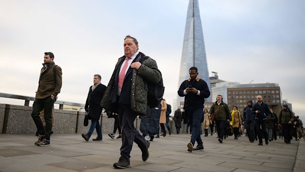 Commuters cross London Bridge during the morning rush hour