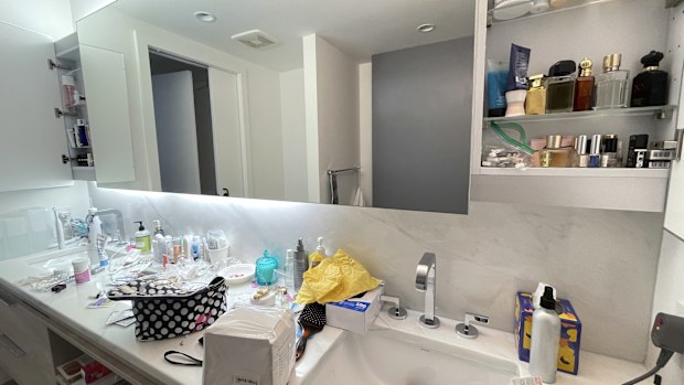 A young female's double sink cluttered bathroom in a fancy high- rise building in Los Angeles!
