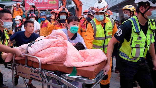 A trapped victim is carried on a stretcher as the victim was found and rescued by firefighters from a collapsed building in Yuli township, Hualien County, eastern Taiwan, Sunday, Sept. 18, 2022. A strong earthquake shook much of Taiwan on Sunday, toppling at least one building and trapping two people inside and knocking part of a passenger train off its tracks at a station.(Hualien City Government via AP)