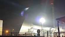A searchlight illuminates a hole in the roof of a damaged sarcophagus that covers the destroyed 4th reactor of Chernobyl nuclear power plant.